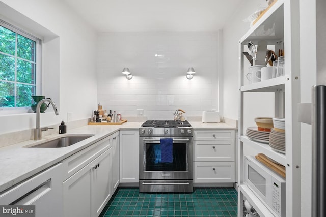 3503 Martha Custis Dr, Alexandria, VA 22302 - kitchen featuring stainless steel gas range oven, a sink, dark tile patterned flooring, and light countertops