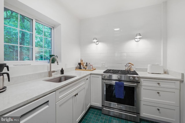 3503 Martha Custis Dr, Alexandria, VA 22302 - kitchen featuring stainless steel gas range, a sink, light countertops, white cabinetry, and dark tile patterned flooring
