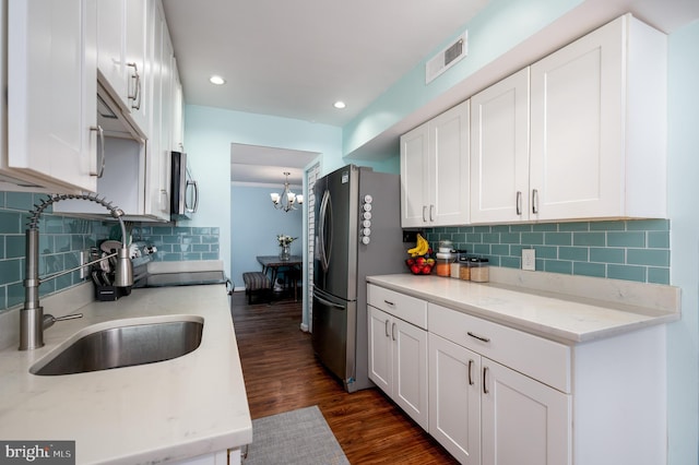 7708 Hanover Pkwy Unit 303, Greenbelt, MD 20770 - kitchen featuring a sink, stainless steel appliances, white cabinetry, a chandelier, and dark wood-type flooring