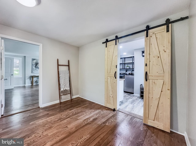 4920 Ed Mcclain Rd, Monrovia, MD 21770 - unfurnished room with a barn door, washer / clothes dryer, wood finished floors, and baseboards