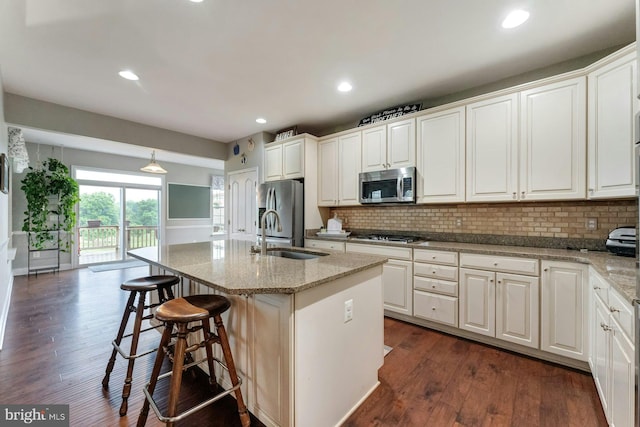 43268 Heavenly Cir, Leesburg, VA 20176 - kitchen featuring a sink, appliances with stainless steel finishes, dark wood-style floors, a kitchen breakfast bar, and decorative backsplash