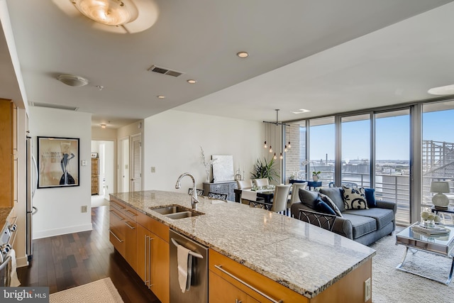 675 President St Unit 2105, Baltimore, MD 21202 - kitchen featuring a sink, appliances with stainless steel finishes, brown cabinetry, light stone counters, and dark wood-type flooring