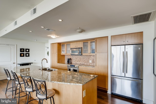 675 President St Unit 2105, Baltimore, MD 21202 - kitchen with appliances with stainless steel finishes, a sink, a breakfast bar, decorative backsplash, and dark wood-type flooring