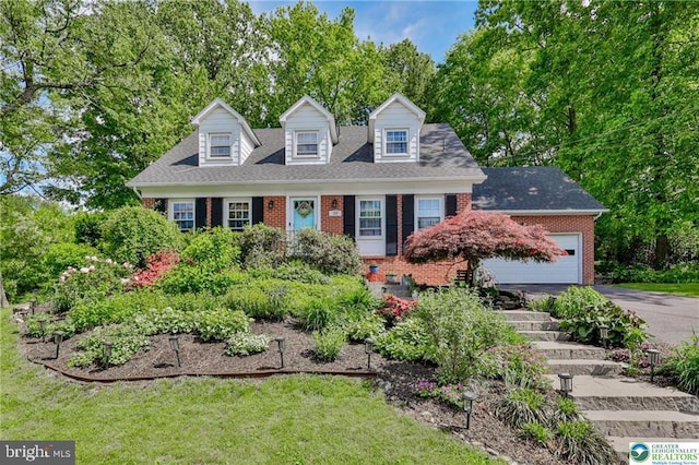 113 S Fairview St, Macungie, PA 18062 - cape cod house with brick siding, driveway, an attached garage, view of wooded area, and a front lawn
