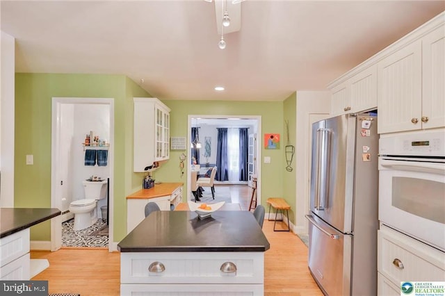 113 S Fairview St, Macungie, PA 18062 - kitchen featuring freestanding refrigerator, oven, white cabinets, dark countertops, and light wood-style flooring