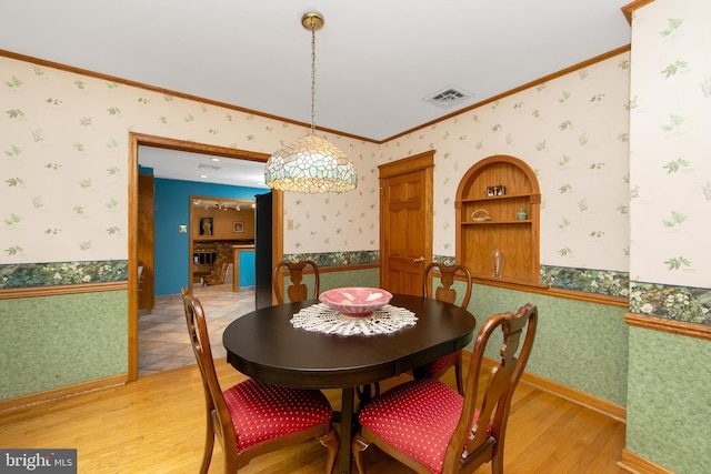 130 Bellmawr Ave, Haddon Heights, NJ 08035 - dining area with wallpapered walls, light wood-style floors, crown molding, and wainscoting