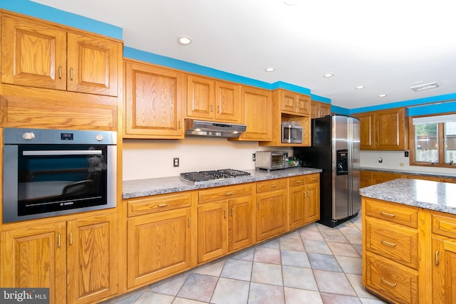 130 Bellmawr Ave, Haddon Heights, NJ 08035 - kitchen featuring appliances with stainless steel finishes, brown cabinetry, light stone countertops, recessed lighting, and under cabinet range hood