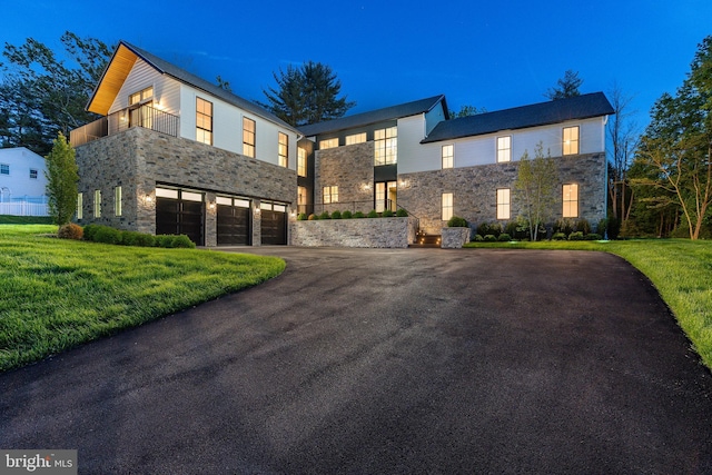 918 Ethan Allen Rd, Berwyn, PA 19312 - contemporary home with stone siding, a balcony, a garage, a front lawn, and asphalt driveway
