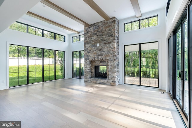 918 Ethan Allen Rd, Berwyn, PA 19312 - unfurnished living room with beam ceiling, a high ceiling, a fireplace, and wood finished floors