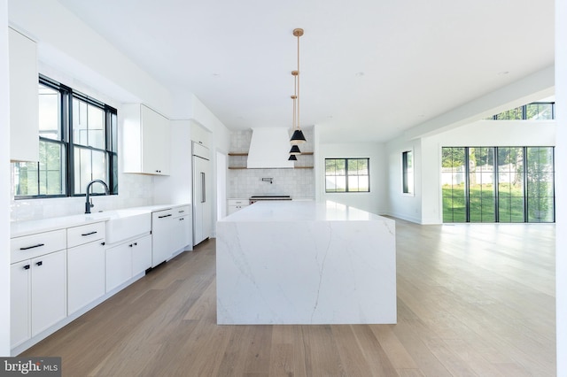 918 Ethan Allen Rd, Berwyn, PA 19312 - kitchen with a sink, open shelves, backsplash, light wood-type flooring, and paneled refrigerator