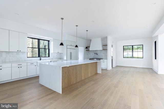 918 Ethan Allen Rd, Berwyn, PA 19312 - kitchen with paneled built in fridge, backsplash, light wood-style floors, light countertops, and custom exhaust hood