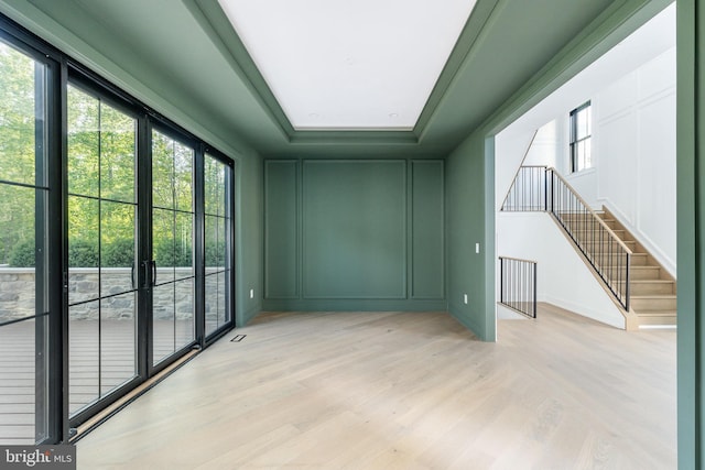 918 Ethan Allen Rd, Berwyn, PA 19312 - spare room featuring a raised ceiling, light wood finished floors, a decorative wall, and stairway