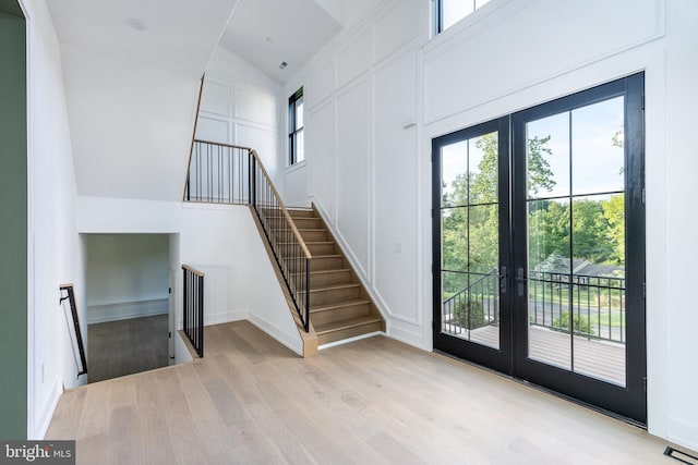 918 Ethan Allen Rd, Berwyn, PA 19312 - foyer entrance with french doors, light wood finished floors, stairway, lofted ceiling, and a decorative wall