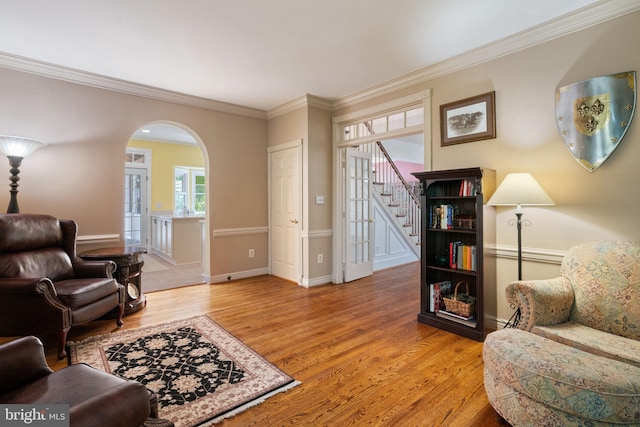 43971 Urbancrest Ct, Ashburn, VA 20147 - living area with arched walkways, light wood-type flooring, stairs, crown molding, and baseboards