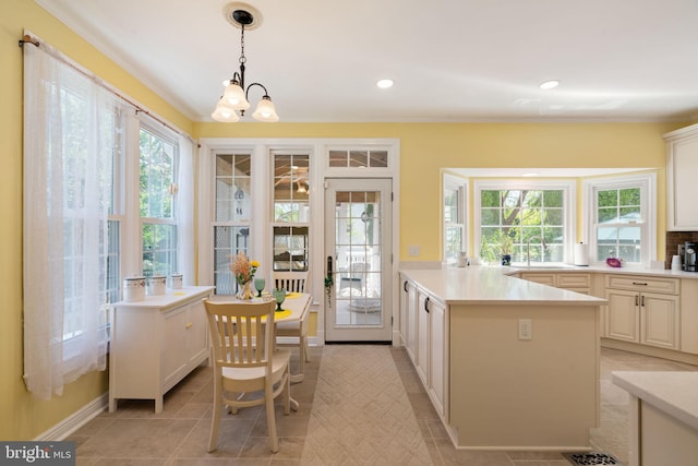 43971 Urbancrest Ct, Ashburn, VA 20147 - kitchen featuring a sink, healthy amount of natural light, light countertops, crown molding, and decorative light fixtures