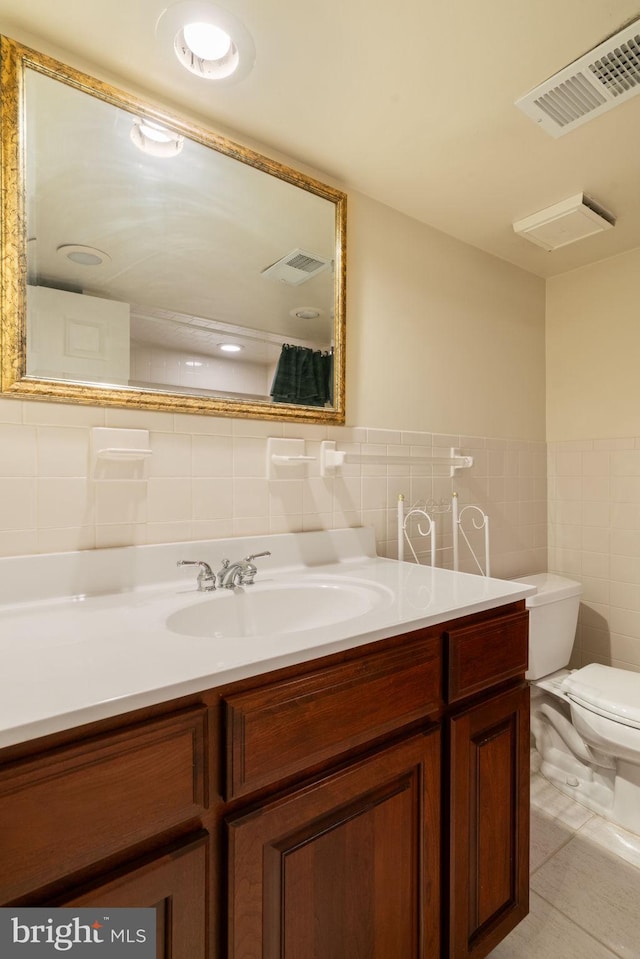 43971 Urbancrest Ct, Ashburn, VA 20147 - bathroom featuring tile walls, toilet, vanity, tile patterned flooring, and wainscoting