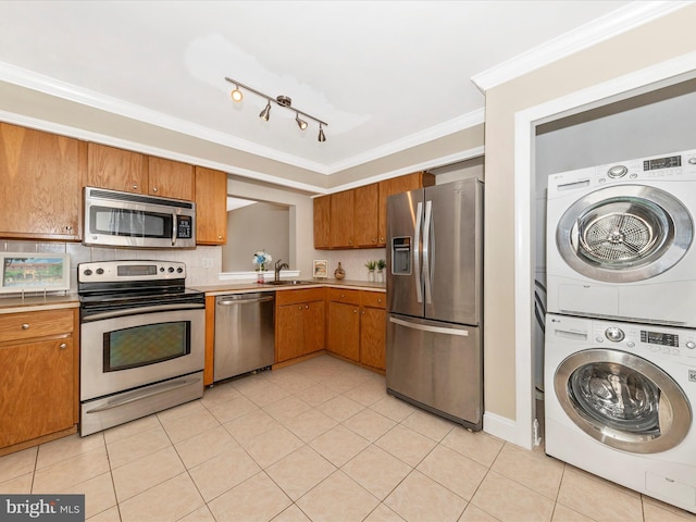 231 Coventry Sq Unit 231, Sterling, VA 20164 - kitchen with appliances with stainless steel finishes, stacked washer and clothes dryer, a sink, brown cabinets, and light countertops