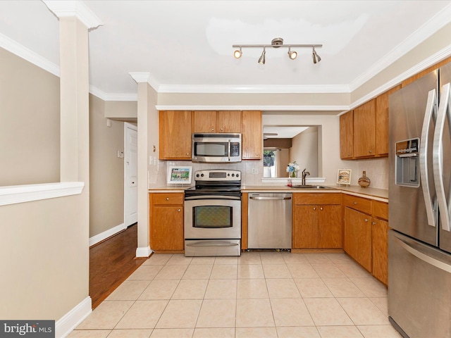 231 Coventry Sq Unit 231, Sterling, VA 20164 - kitchen with stainless steel appliances, light countertops, a sink, brown cabinets, and ornamental molding