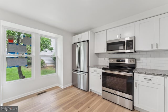 13929 Carthage Cir, Burtonsville, MD 20866 - kitchen with stainless steel appliances, baseboards, decorative backsplash, light wood-type flooring, and white cabinetry