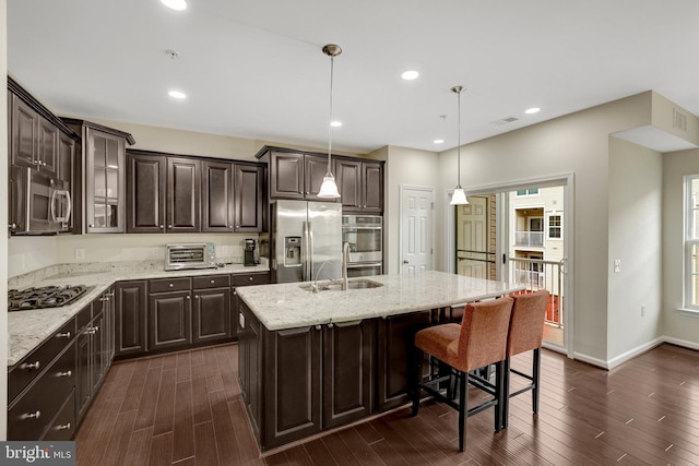 43469 Town Gate Sq, Chantilly, VA 20152 - kitchen featuring appliances with stainless steel finishes, dark wood finished floors, dark brown cabinets, glass insert cabinets, and a breakfast bar area