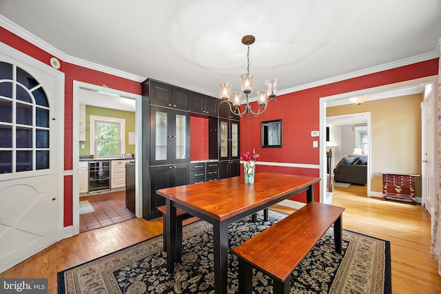 201 S Rd, Wilmington, DE 19809 - dining room featuring wine cooler, a chandelier, light wood-type flooring, crown molding, and baseboards