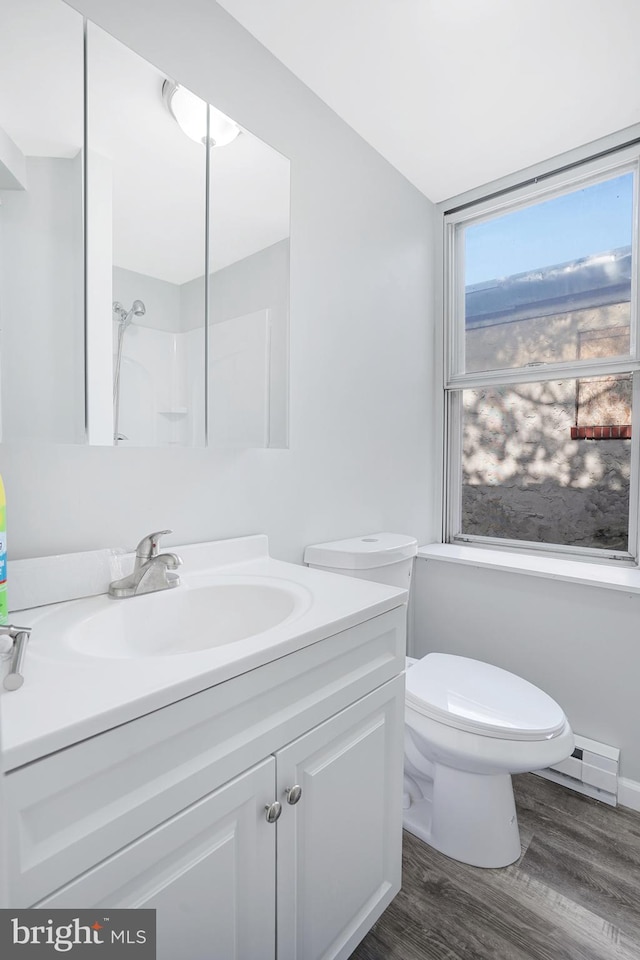 565 Line St, Camden, NJ 08103 - full bath featuring vanity, a baseboard heating unit, toilet, wood finished floors, and a shower