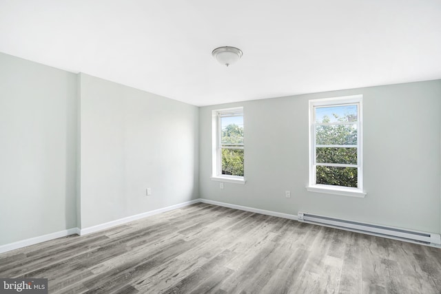 565 Line St, Camden, NJ 08103 - empty room with baseboard heating, wood finished floors, and baseboards