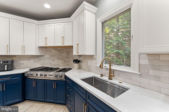 22962 Lois Ln, Brambleton, VA 20148 - kitchen featuring blue cabinets, a sink, stainless steel gas cooktop, and white cabinetry