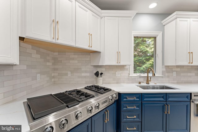 22962 Lois Ln, Brambleton, VA 20148 - kitchen featuring stainless steel gas stovetop, a sink, blue cabinets, white cabinetry, and decorative backsplash