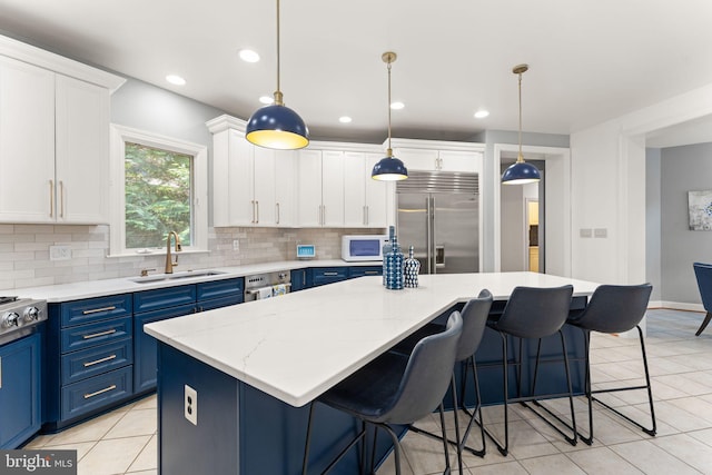 22962 Lois Ln, Brambleton, VA 20148 - kitchen with a sink, stainless steel appliances, blue cabinetry, decorative backsplash, and light tile patterned flooring