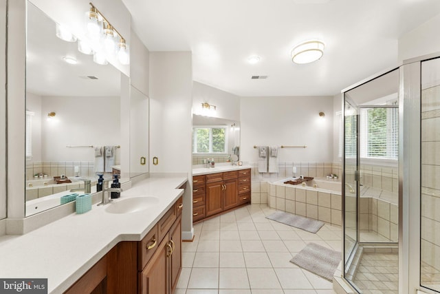 22962 Lois Ln, Brambleton, VA 20148 - bathroom featuring two vanities, a bath, healthy amount of natural light, and tile patterned floors