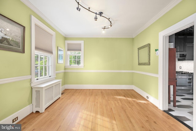 1107 Kenmore Ave, Fredericksburg, VA 22401 - empty room featuring rail lighting, hardwood / wood-style flooring, radiator, crown molding, and baseboards