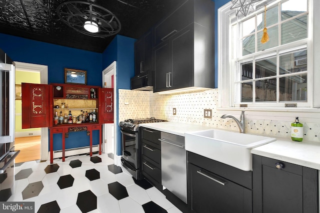 1107 Kenmore Ave, Fredericksburg, VA 22401 - kitchen featuring stainless steel appliances, dark cabinetry, a sink, and a baseboard heating unit