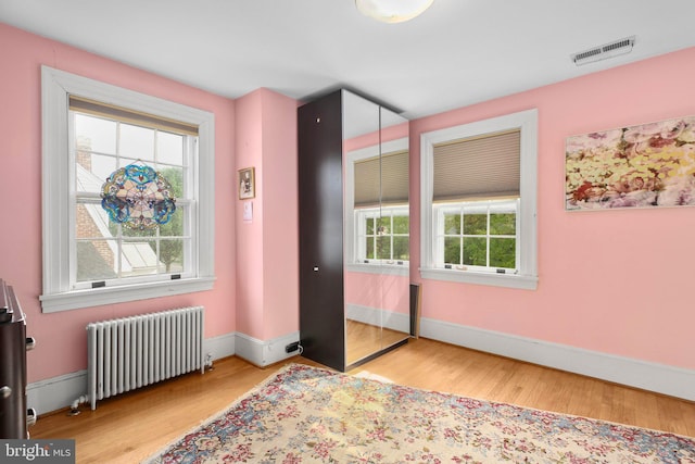 1107 Kenmore Ave, Fredericksburg, VA 22401 - bedroom with radiator, multiple windows, light wood-style floors, and baseboards