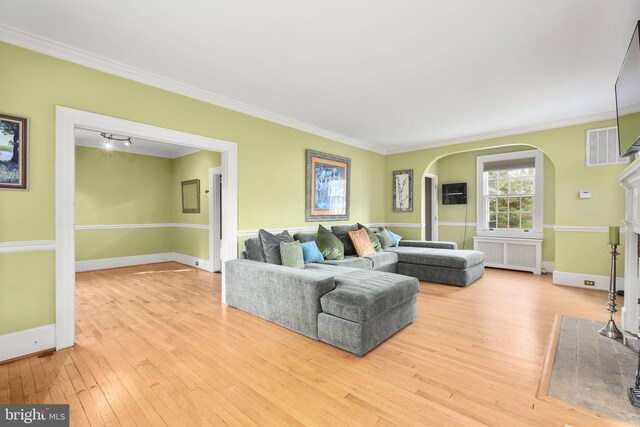 1107 Kenmore Ave, Fredericksburg, VA 22401 - living room featuring radiator heating unit, arched walkways, ornamental molding, wood-type flooring, and baseboards