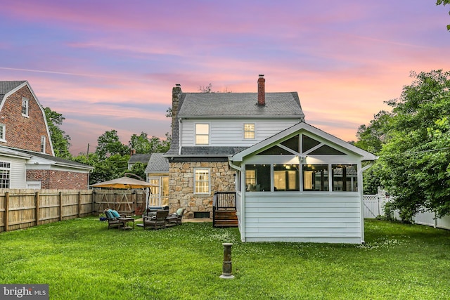 1107 Kenmore Ave, Fredericksburg, VA 22401 - back of house featuring a chimney, stone siding, a sunroom, and roof with shingles