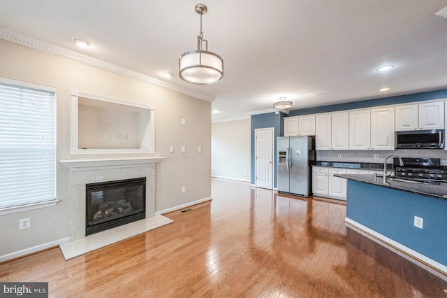 3416 Barnhouse Dr, Edgewater, MD 21037 - kitchen featuring appliances with stainless steel finishes, ornamental molding, white cabinets, light wood-style flooring, and baseboards