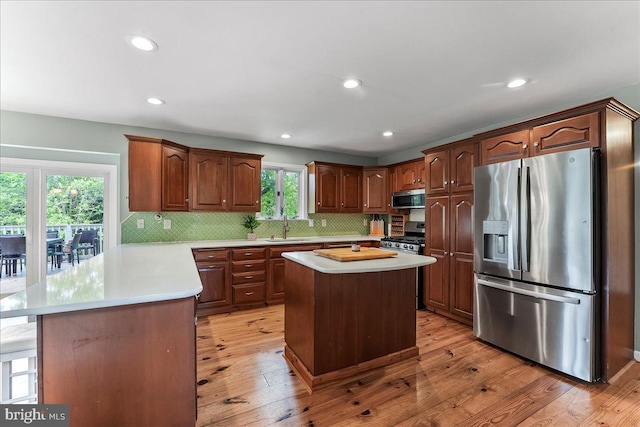 11 White Oak Dr, West Grove, PA 19390 - kitchen featuring appliances with stainless steel finishes, light countertops, light wood-style flooring, a sink, and tasteful backsplash