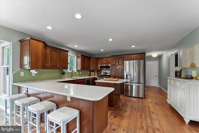 11 White Oak Dr, West Grove, PA 19390 - kitchen featuring appliances with stainless steel finishes, a sink, a kitchen island, light wood-style floors, and backsplash