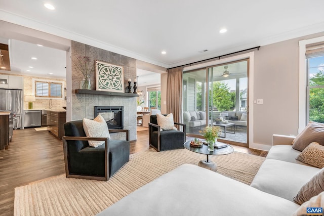 729 Highgate Row, Crozet, VA 22932 - living area featuring crown molding, a tiled fireplace, recessed lighting, wood finished floors, and baseboards