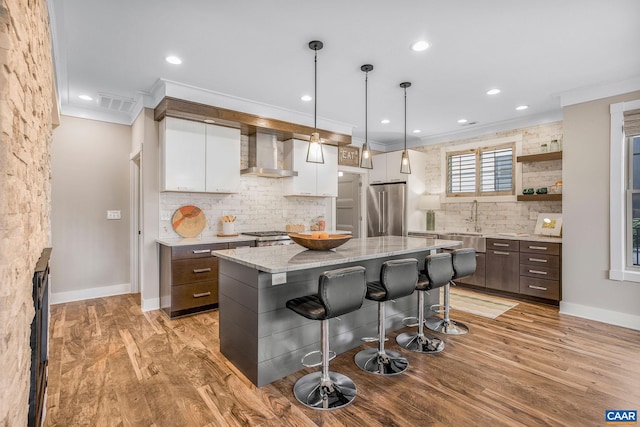 729 Highgate Row, Crozet, VA 22932 - kitchen featuring high end fridge, wall chimney range hood, white cabinetry, a kitchen breakfast bar, and decorative backsplash