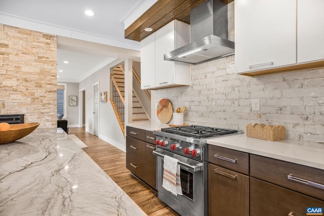 729 Highgate Row, Crozet, VA 22932 - kitchen with luxury range, wall chimney exhaust hood, white cabinetry, ornamental molding, and baseboards