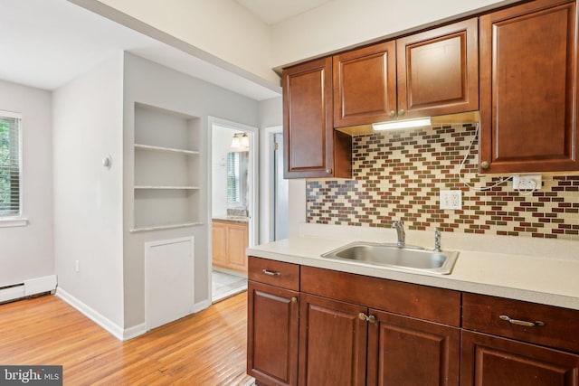 1100 Tyson Ave Unit A-10, Abington, PA 19001 - kitchen featuring a sink, light countertops, light wood-style flooring, decorative backsplash, and baseboards