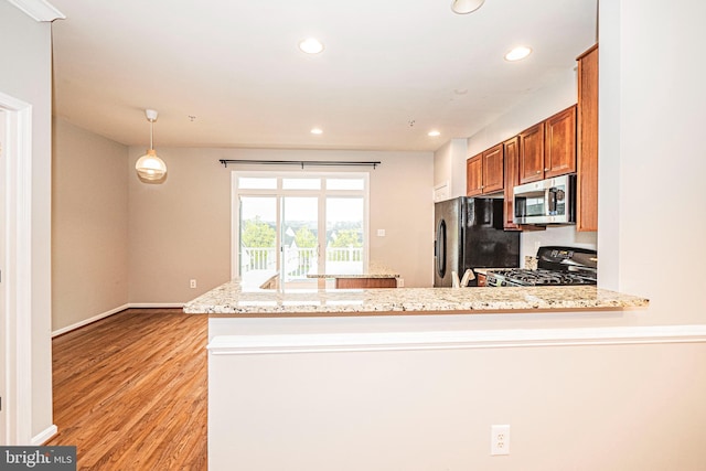 11919 Little Seneca Pkwy, Clarksburg, MD 20871 - kitchen with gas range, stainless steel microwave, freestanding refrigerator, brown cabinets, and light wood-style floors