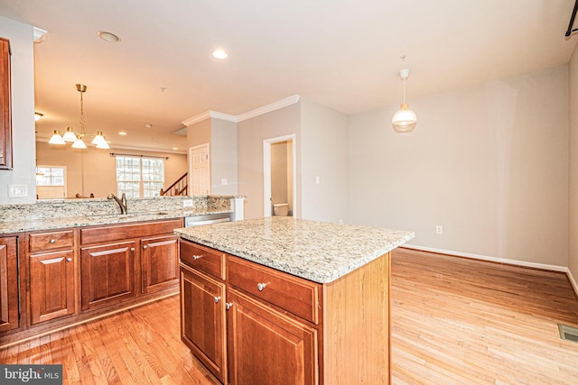 11919 Little Seneca Pkwy, Clarksburg, MD 20871 - kitchen with a sink, light wood-style flooring, light stone countertops, hanging light fixtures, and crown molding