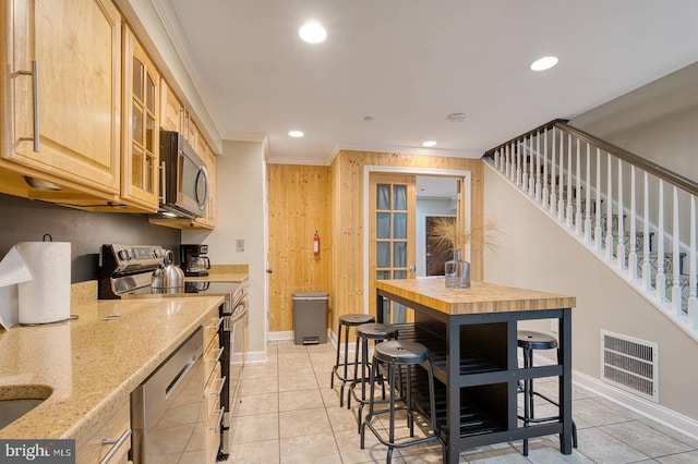 1337 Harvard St NW Unit 1, Washington, DC 20009 - kitchen featuring stainless steel appliances, crown molding, baseboards, glass insert cabinets, and light stone counters