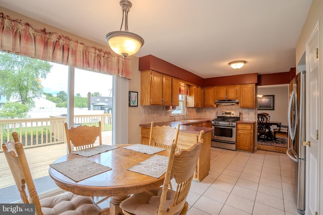 5 Wetherhill Way, Dayton, NJ 08810 - kitchen with appliances with stainless steel finishes, decorative backsplash, under cabinet range hood, light tile patterned floors, and brown cabinets