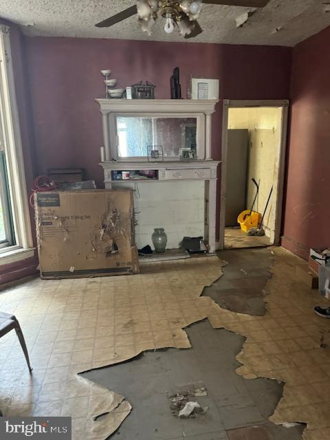 518 S 55th St, Philadelphia, PA 19143 - unfurnished living room featuring light flooring, ceiling fan, and a textured ceiling