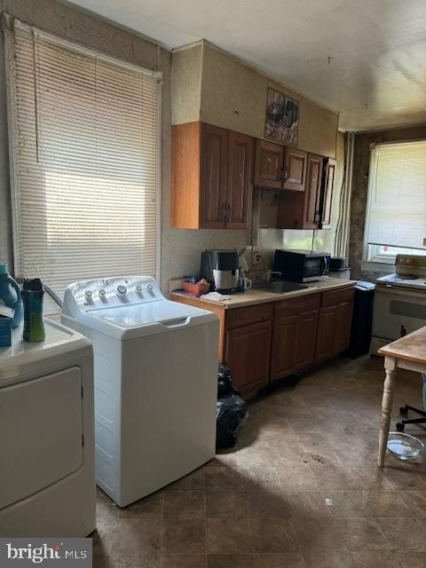 518 S 55th St, Philadelphia, PA 19143 - laundry room featuring washing machine and clothes dryer and healthy amount of natural light