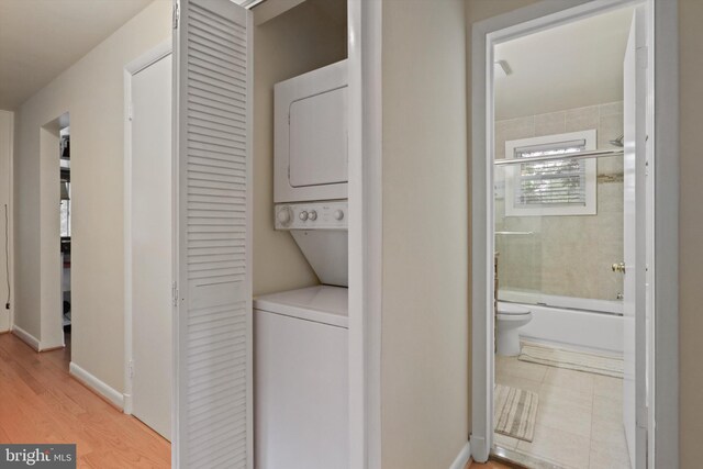 3615 22nd St N, Arlington, VA 22207 - laundry room with stacked washer and clothes dryer, baseboards, and light wood finished floors